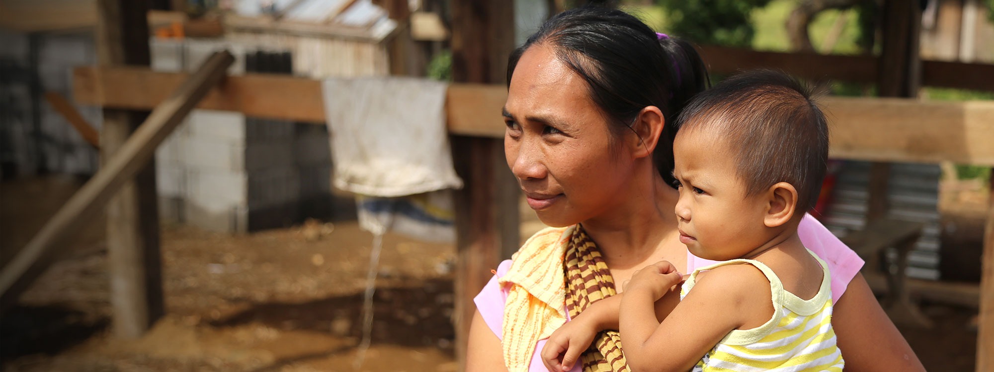 Woman and baby look into the distance in the Philippines