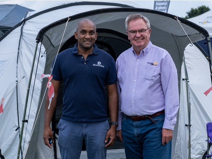 Gordon McInally and another ShelterBox volunteer stand in front of a tent